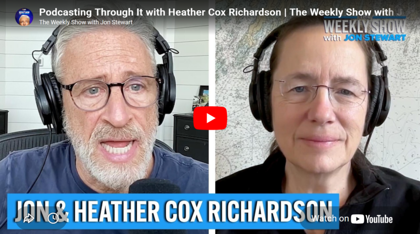Screen grab of YouTube preview of Jon Stewart and Heather Cox Richardson wearing headphones.